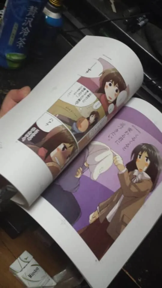 手に持たれたカラー漫画の開かれたページ